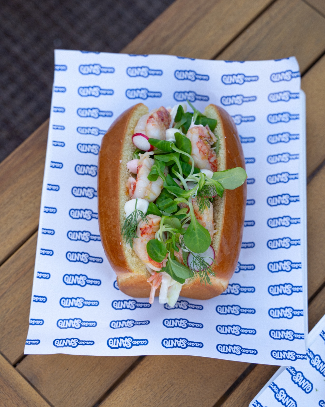 Shrimp roll con gamberi e insalata su carta con logo Casa Santo