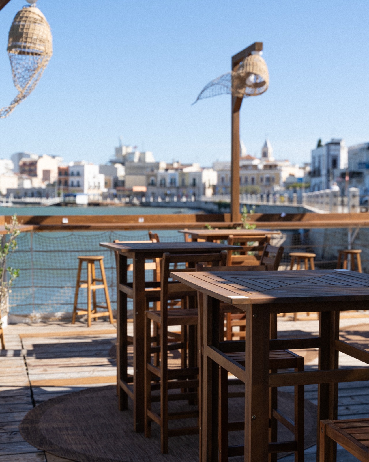 Terrazza di Casa Santo con tavoli in legno affacciata sul porto di Santo Spirito