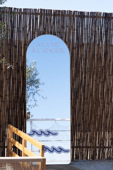 Ingresso di Casa Santo a Santo Spirito: arco con specchio tra canne di bambù e vista sul mare