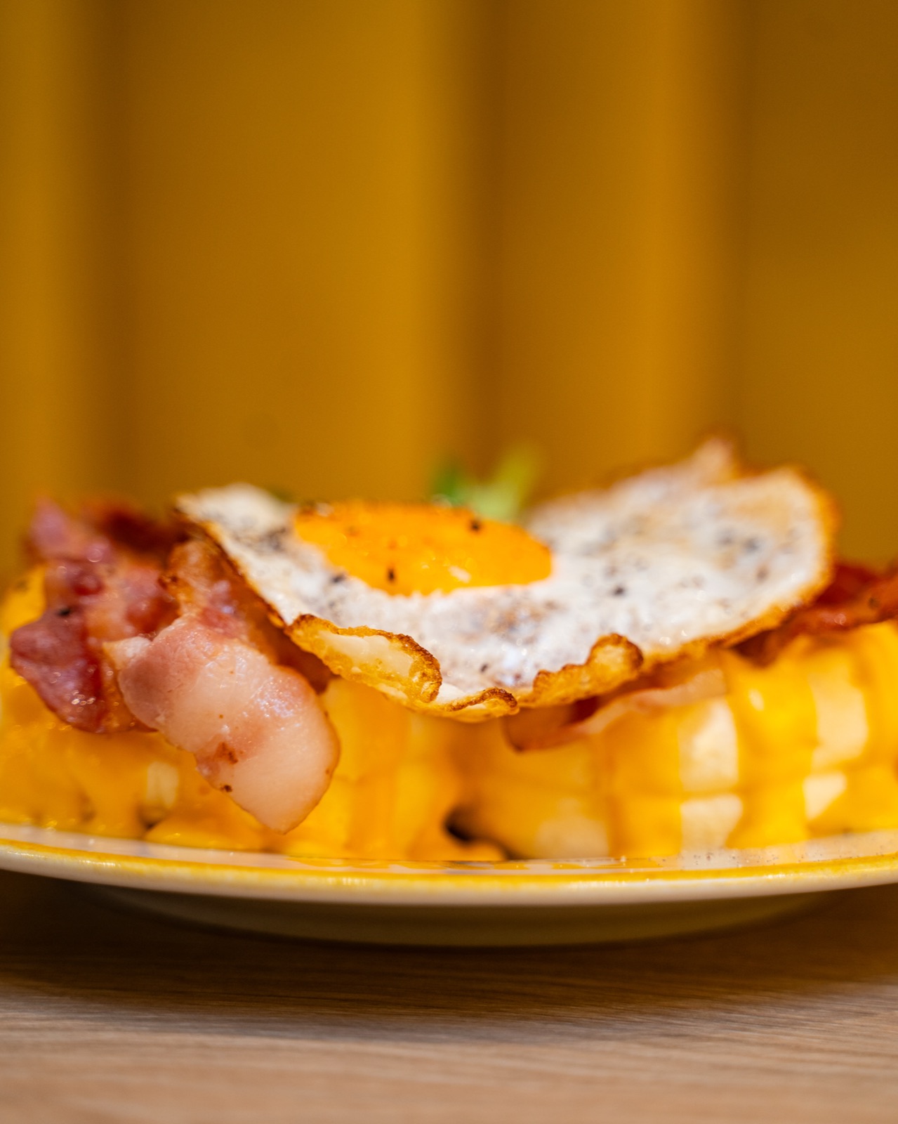 Pancake soufflé salato con uovo e bacon su sfondo giallo, Fuwa