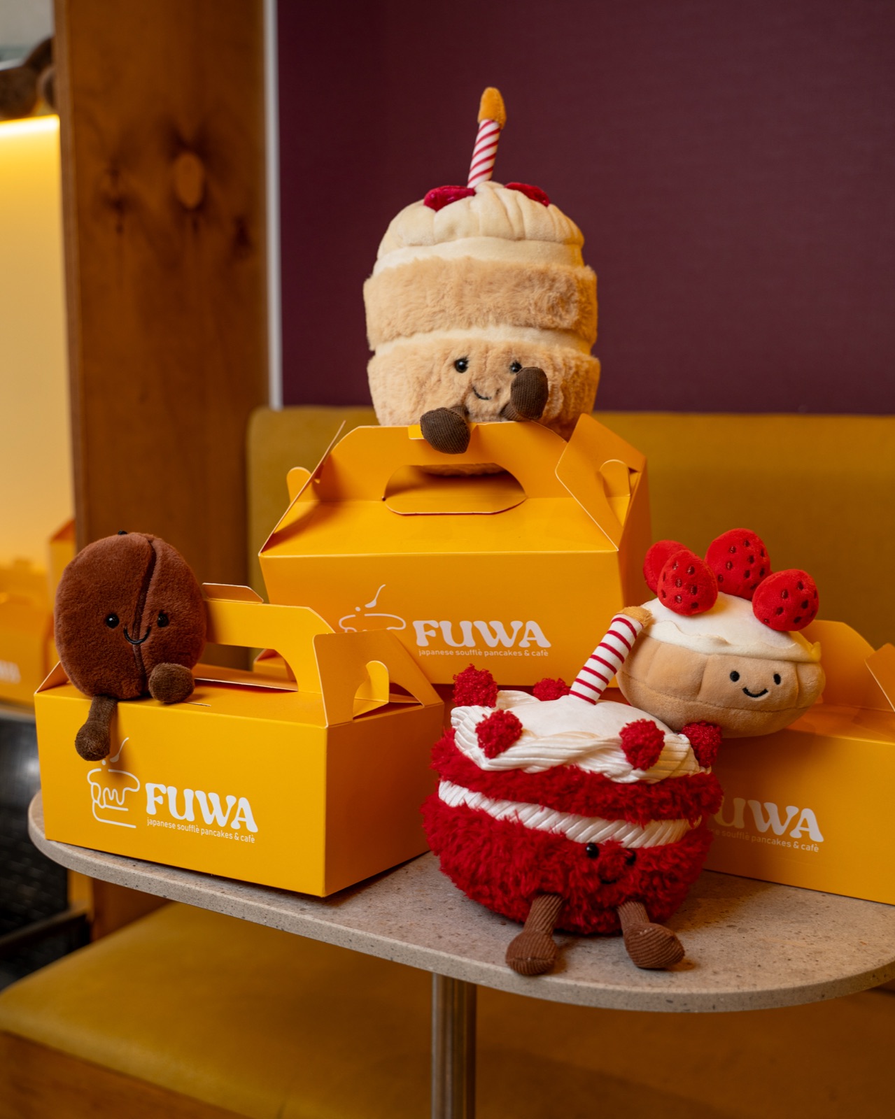 Pupazzi a forma di dolce e scatole regalo gialle con logo Fuwa