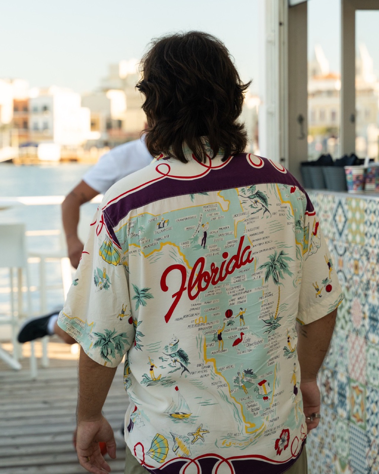 Ragazzo di spalle con camicia Florida in terrazza vista mare, Miami Haus