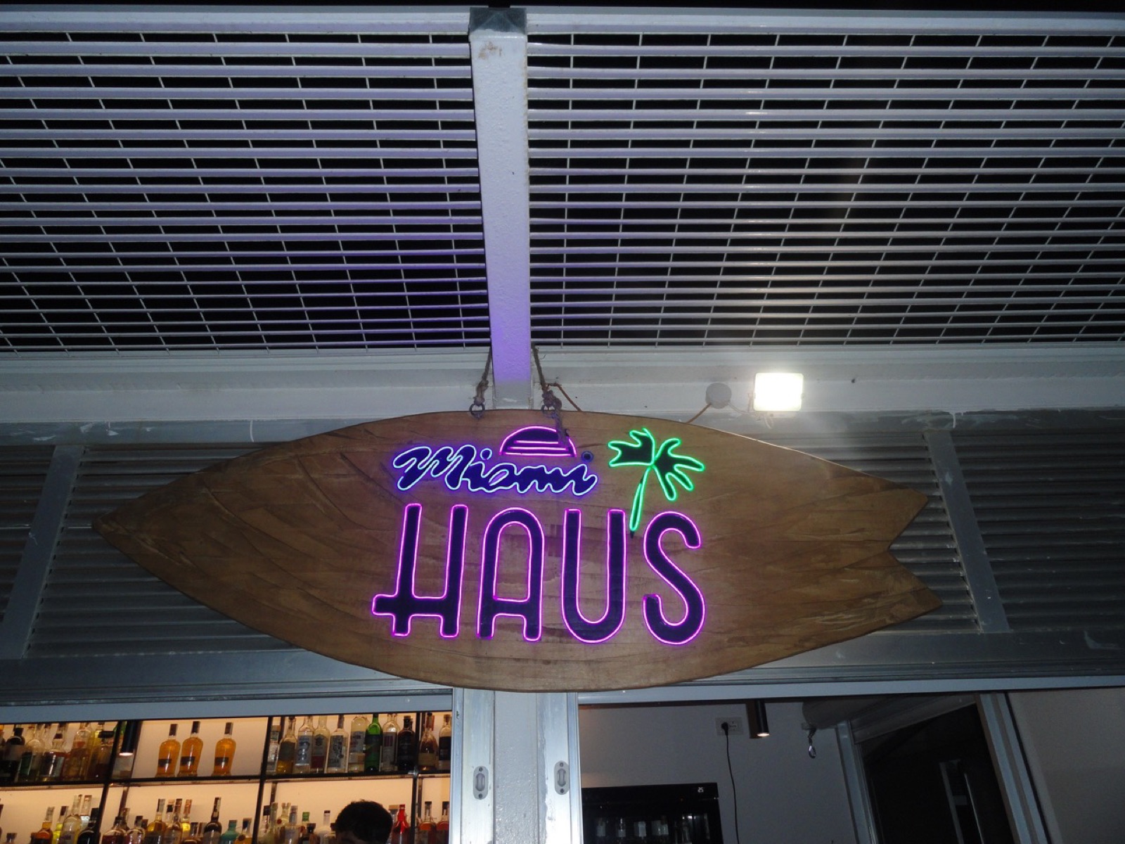 Insegna al neon Miami Haus sopra il bancone del bar