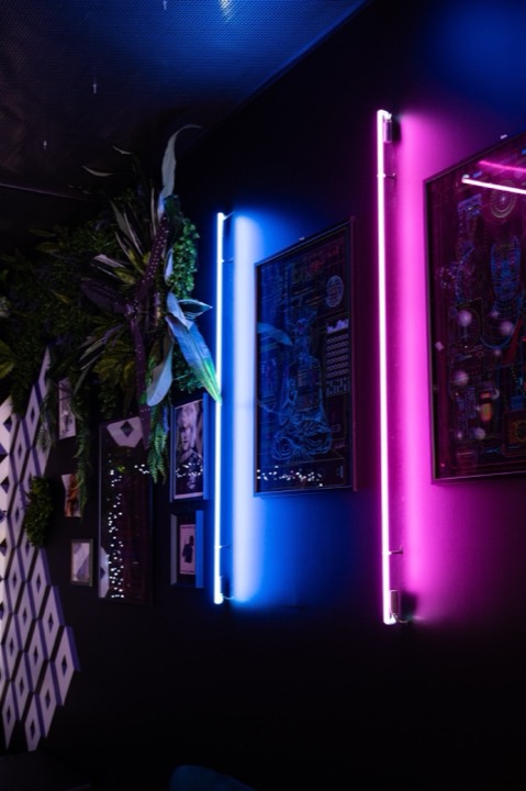 Interno di Haus whisky bar a Bari con luci al neon blu e rosa