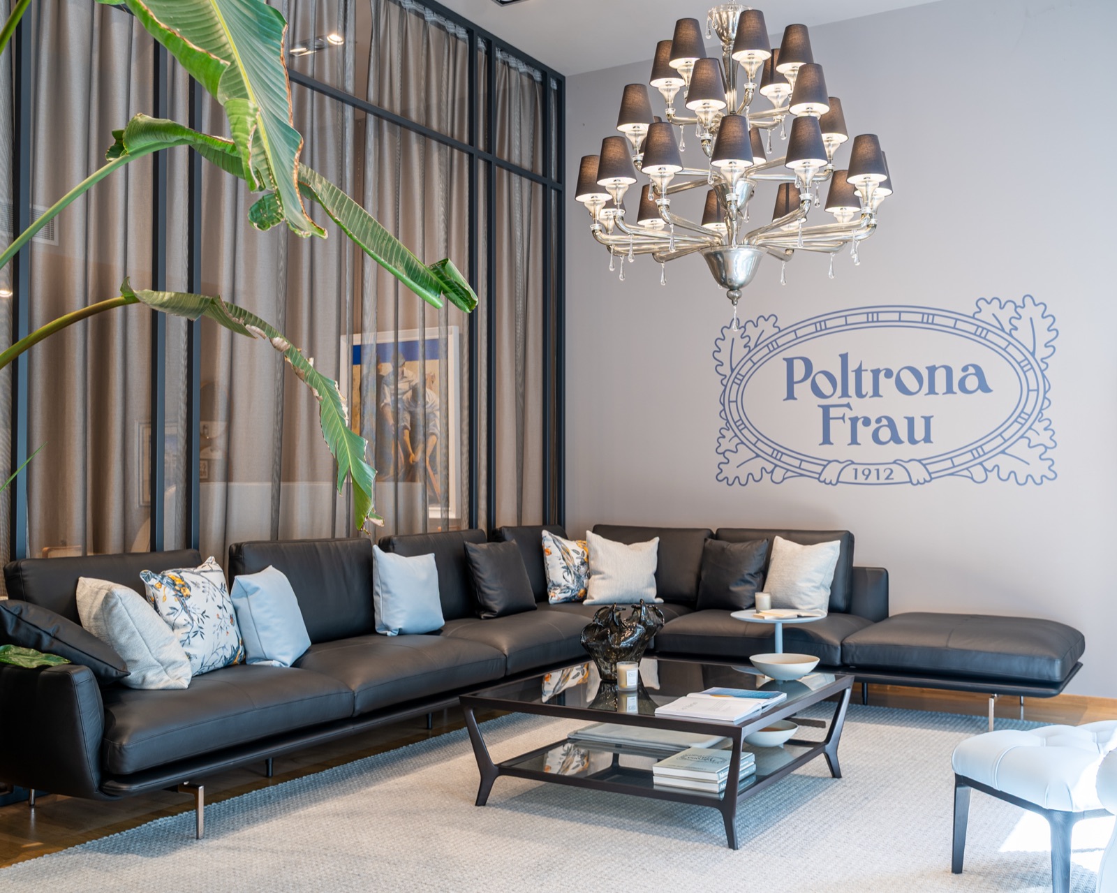 Living Poltrona Frau con divano in pelle nera e lampadario, showroom Linear Design