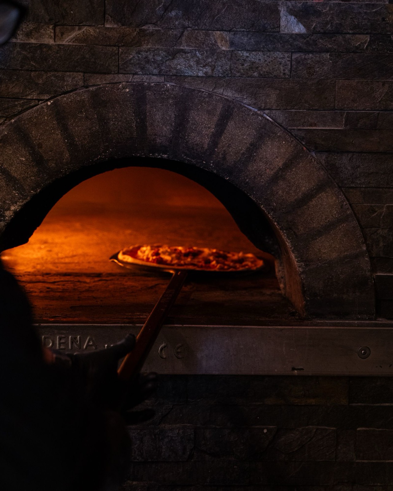 Pizza che cuoce nel forno a legna di Piccinni28