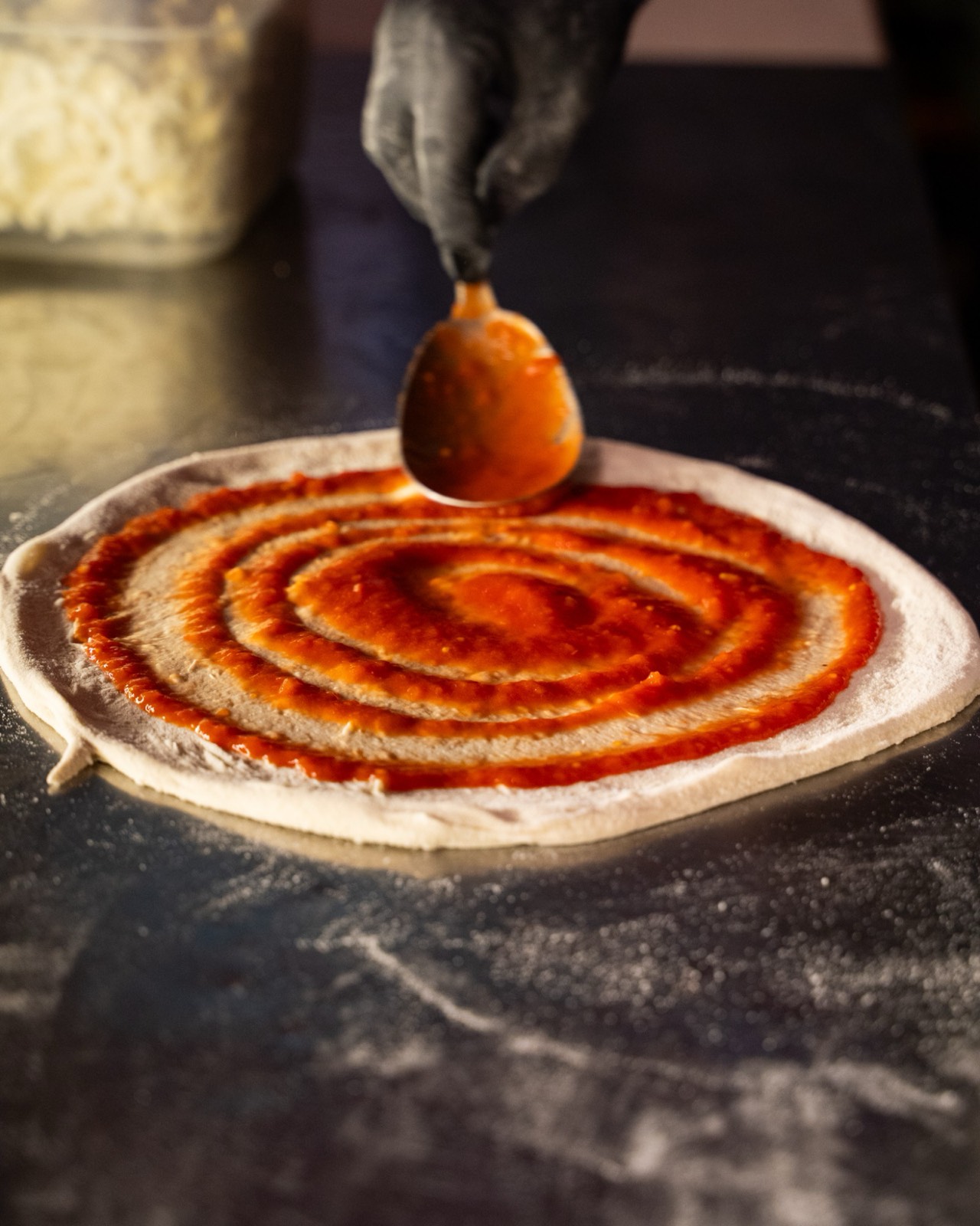 Salsa di pomodoro stesa a spirale sull'impasto, pizzeria Piccinni28