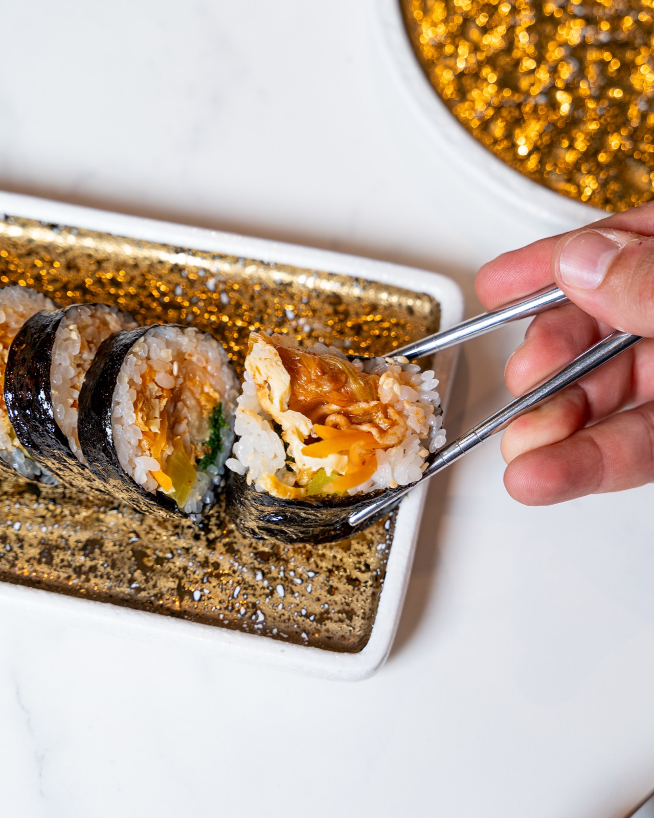 Kimbap tagliato preso con le bacchette, ristorante coreano Sentò a Bari