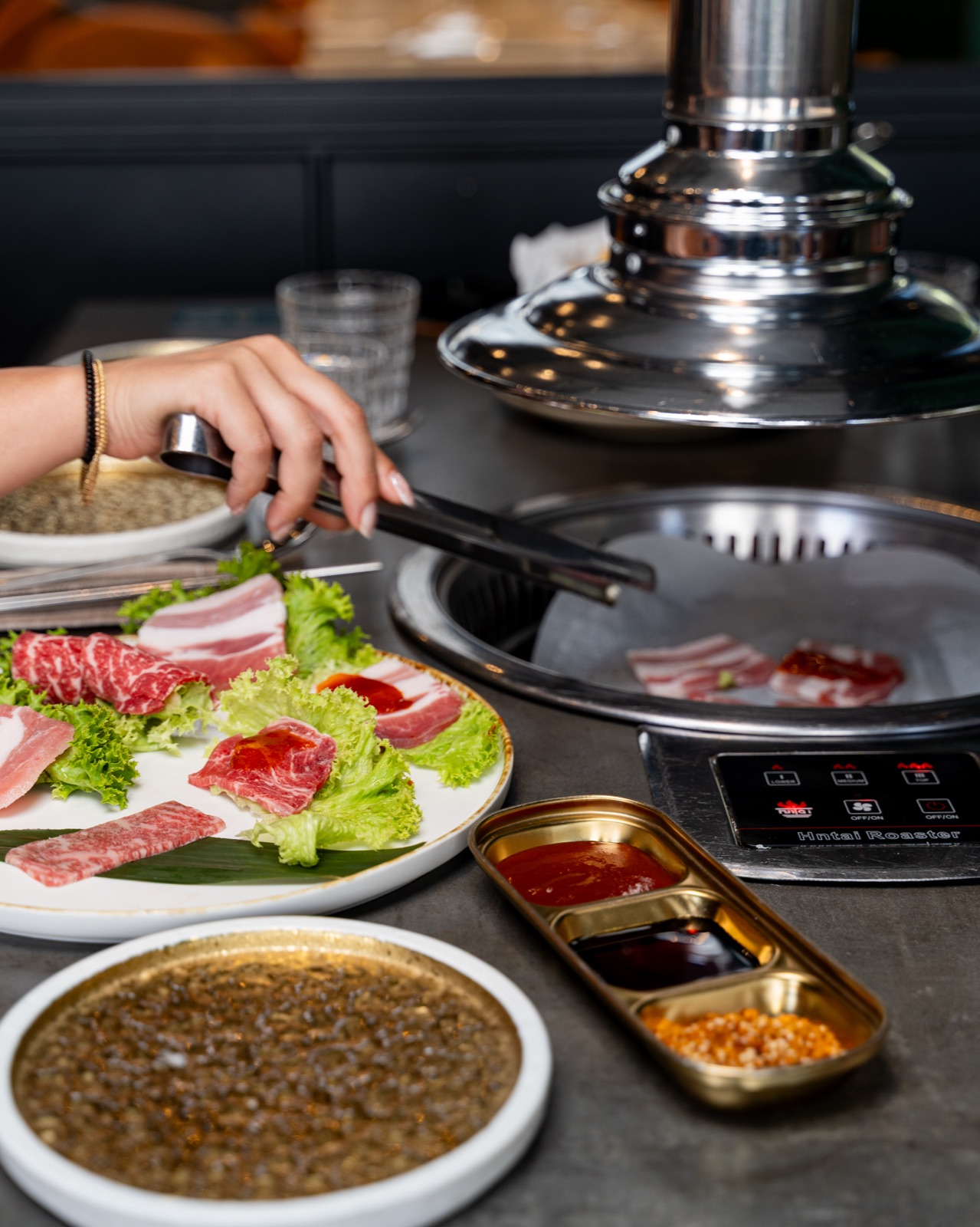 Barbecue coreano al tavolo con griglia e carne, Sentò Bari