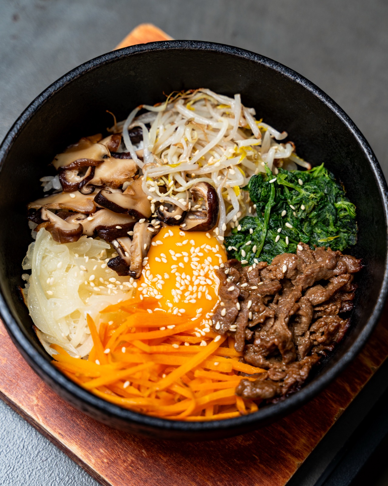 Primo piano del bibimbap con funghi, carote, spinaci e uovo, Sentò