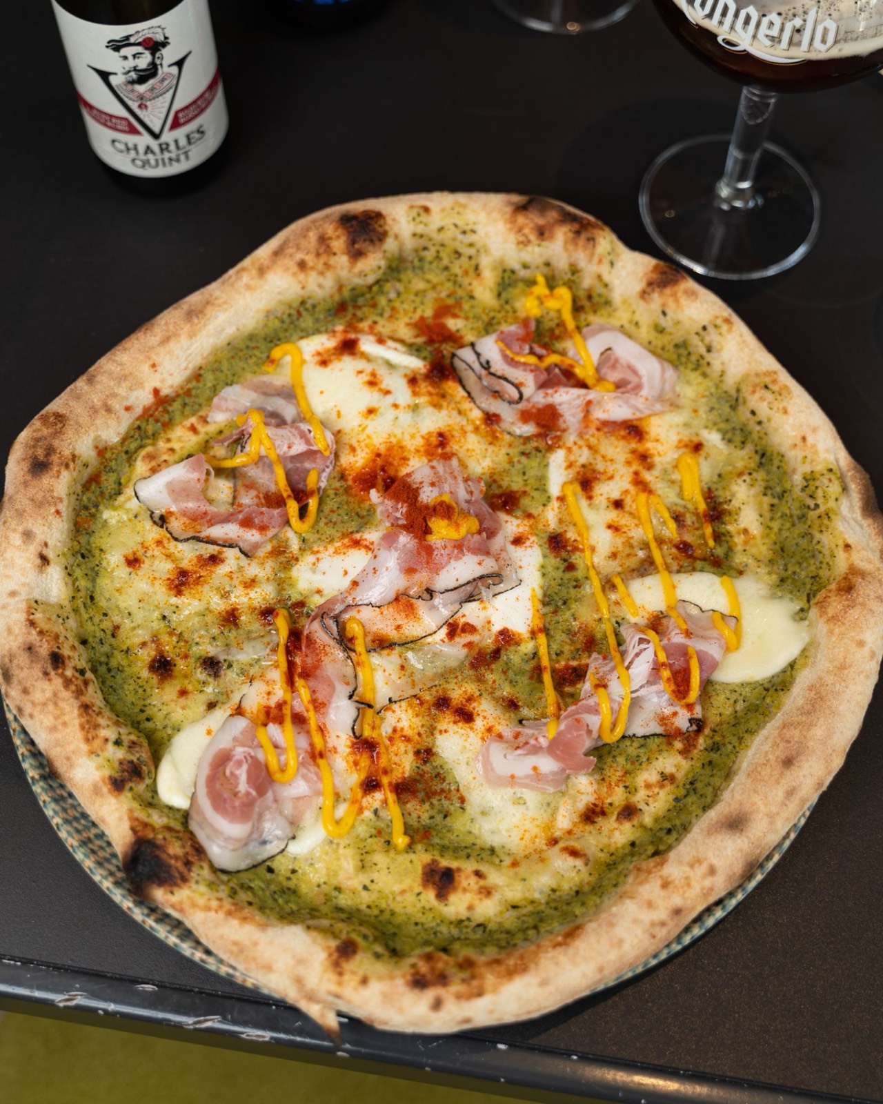 Pizza con pesto, guanciale e paprika accanto a una birra, Vent8 Bari