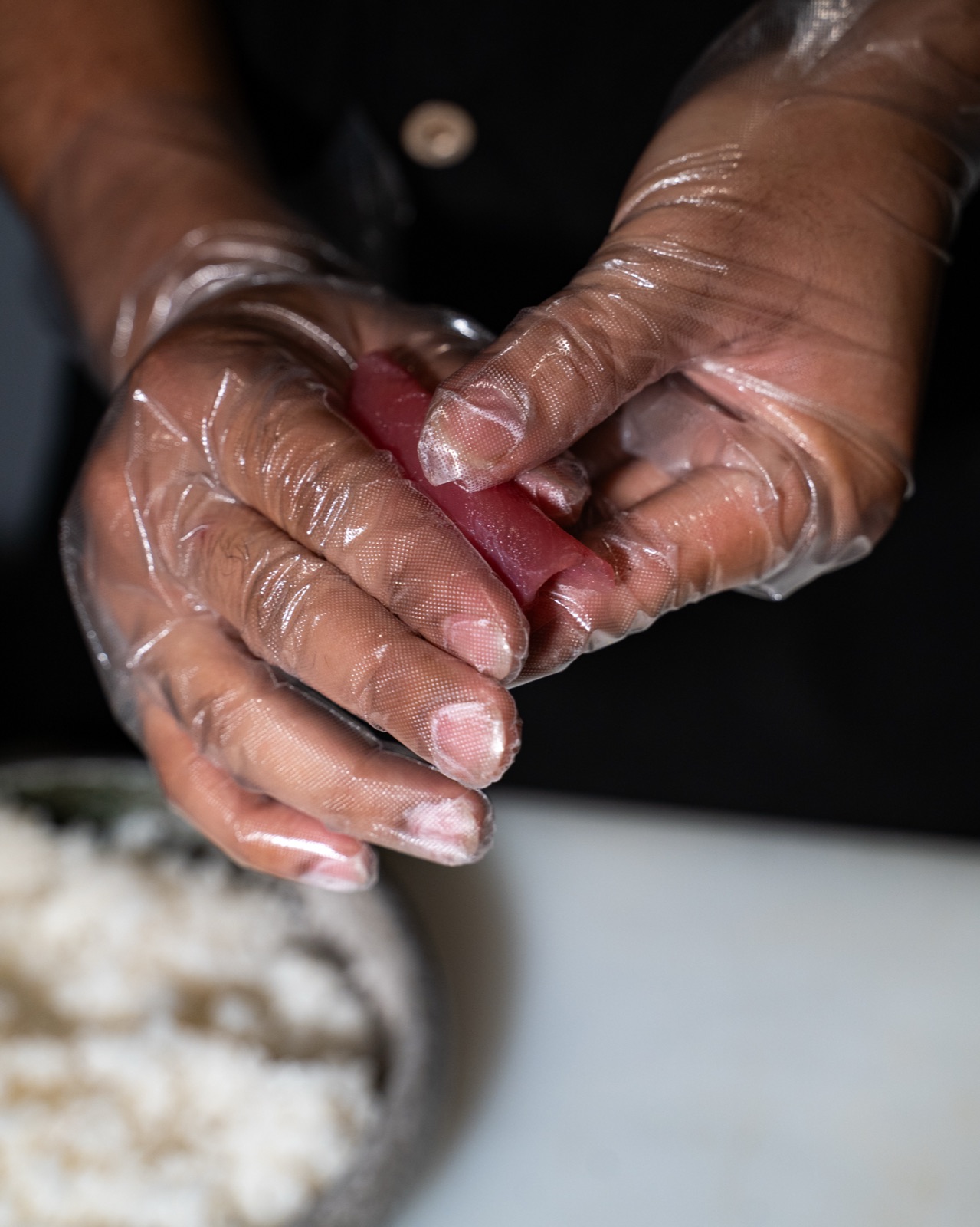 Mani dello chef che modellano un nigiri di tonno, Yuzu Bari